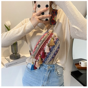 Detail of bohemian chest bag featuring multi-colored tassels and woven geometric strap