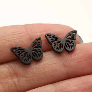 Close-up of black butterfly stud earrings showing hollow wings and exact size in hand