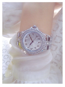 Détail d'une montre de luxe argentée sertie de strass avec index en chiffres arabes