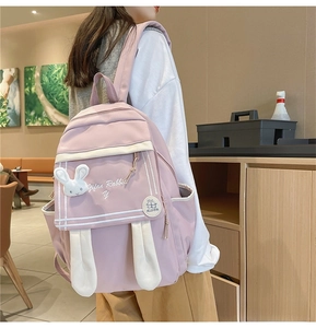 Detailed side view of pink anime backpack with cute rabbit ears and plush decor