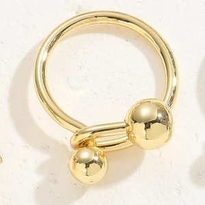 Vue détaillée de la bague papillon dorée avec des sphères métalliques polies et brillantes