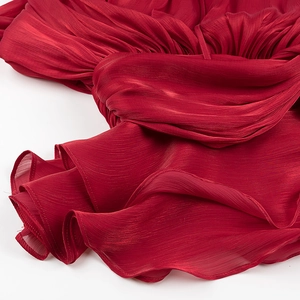 Detailed macro shot of dark red pleated fabric texture and vertical pleating technique