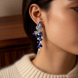 Close-up of model wearing blue butterfly wing drop earrings with sparkling zircon stones