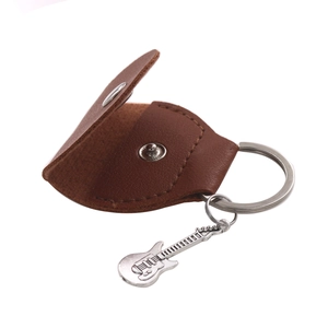 Detail of dark brown leather guitar pick holder with a metal guitar pendant and keychain