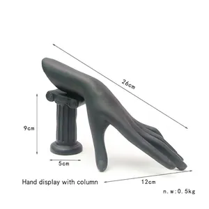 Detailed view of black resin hand mannequin jewelry stand on a Roman column base