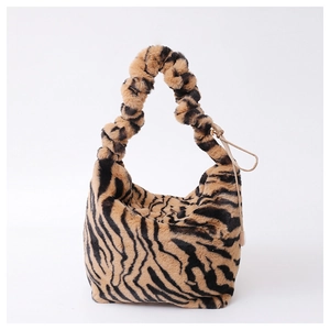 Faux fur tiger print crossbody bag featuring a unique scrunchie handle on white backdrop