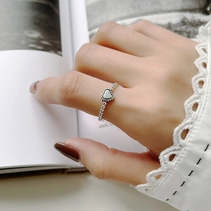 Close-up of 925 sterling silver heart ring with beaded band worn on a hand