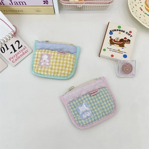 Close-up of quilted plaid coin purses with clear card slots and bear patterns
