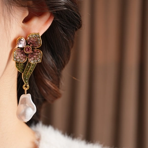 Gros plan de boucles d'oreilles vintage fleurs avec cristaux roses et perle sur mannequin