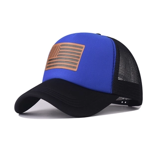Detail of blue and black trucker hat featuring a brown American flag leather patch