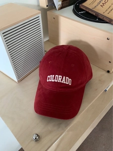 Close-up of red brushed cotton baseball cap with white Colorado embroidery on a table