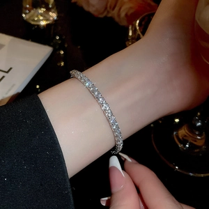 Close-up of a sparkling tennis bracelet with prong-set cubic zirconia on a wrist