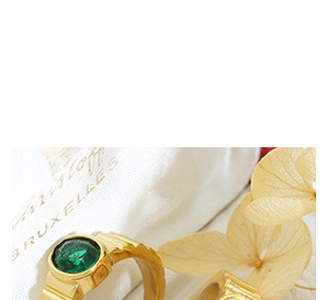 Macro shot of gold-plated French style ring featuring a round green gemstone inlay