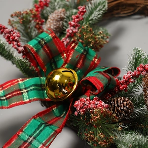 Christmas wreath with pine needles, red berries, pinecones, plaid bow and gold bell