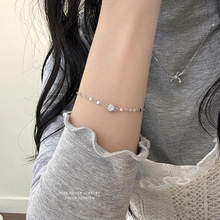 Close-up of a minimalist S925 silver bracelet with geometric charms on a female wrist