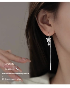 Detail of silver long tassel bow earrings on model with elegant hollow butterfly design