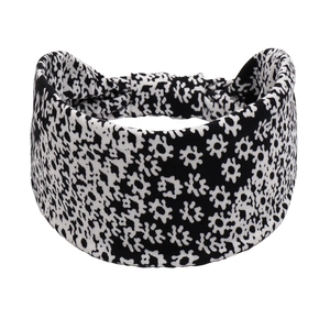 Detail view of wide black floral yoga headband with soft fabric and elastic back
