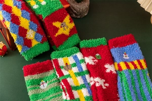Close-up of fluffy Christmas coral fleece socks with reindeer and snowflake patterns