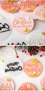 Nahaufnahme von rosa Plätzchenstempel mit Merry Christmas Grüßen für das Backen im Advent
