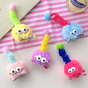 Macro shot of colorful plush hair clips with big eyes and spiral colorful rods