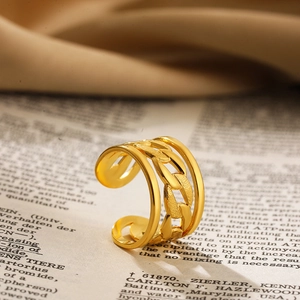 Detail van een gouden holle schakelring met brede band op vintage boekachtergrond