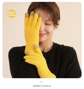Detail of bright yellow thermal knit gloves showing touch screen tips on fingers