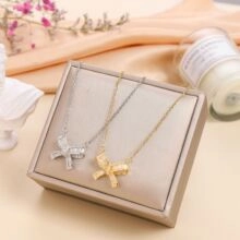 Detail of bow-knot pendants in gold and silver finish on a jewelry display stand