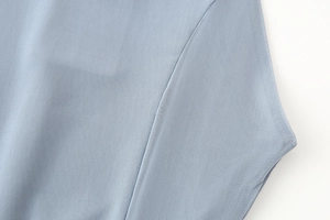 Nahaufnahme von hellblauem Netzgewebe mit professionellen Nähten an einem eleganten Kleid