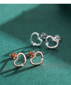 Macro view of silver and rose gold heart earrings with sparkling cubic zirconia