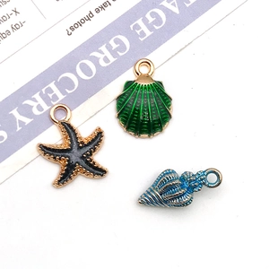 Detail view of colorful enamel charms featuring green shell, black starfish and blue conch