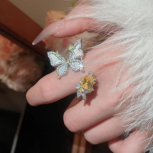 Close-up of silver butterfly ring with white mother-of-pearl and yellow rhinestones