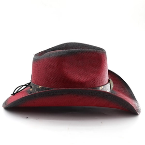 Detail of red and black gradient straw cowboy hat with leather band and metal buckle