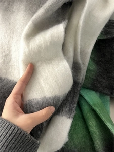 Close-up of thick gradient scarf showing black and white check pattern with soft plush texture