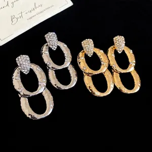 Elegant gold and silver oval drop earrings with shimmering zircon and hammered texture