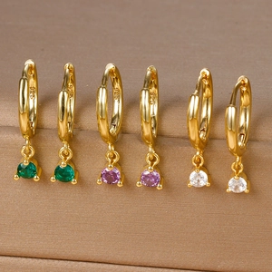 Macro shot of S925 sterling silver gold earrings with green, purple and white zircons