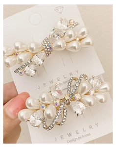 Detailed close-up of butterfly hair clips with white pearls and sparkling crystals