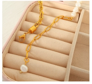 Detail of twisted gold chain and pearl bracelet with lobster clasp in a pink gift box