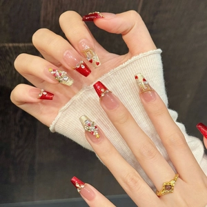Handmade Christmas press-on nails with red glitter, pearls, and heart rhinestones