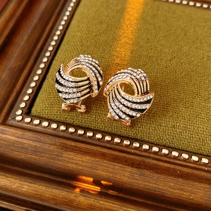 Gros plan de boucles d'oreilles ailes dorées vintage avec cristaux et détails noirs