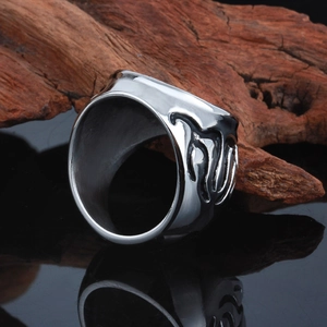 Vintage stainless steel ring for men with unique engraved textures on a dark surface