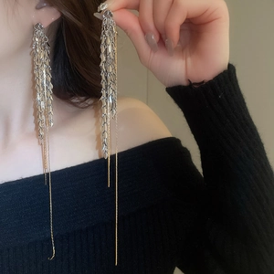 Détail de boucles d'oreilles à pampilles en épi de blé avec des accents dorés