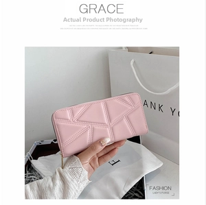 Detail of soft pink PU leather wallet with geometric quilted pattern and gold zipper