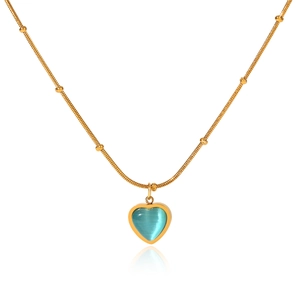 Close-up of golden heart pendant with blue cat eye stone on beaded snake chain