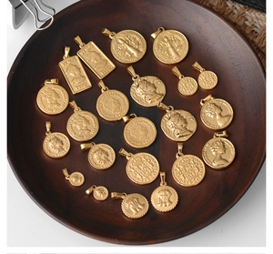 Macro detail of gold-plated roman coin pendants in a vintage circular wooden tray