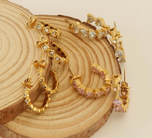 Vue macro de boucles d'oreilles en C plaquées or 18k avec cristaux roses et clairs