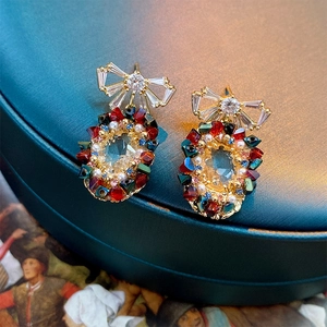 Macro detail of gold vintage earrings with colorful gemstones and pearls on jewelry box