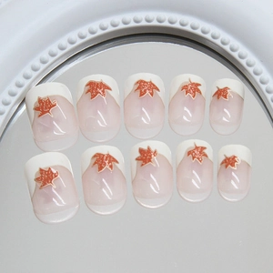 Short square press-on nails with French white tips and glittery orange maple leaf designs