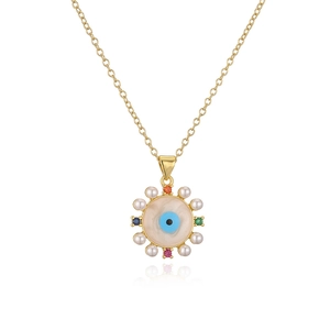 Close-up of 18K gold evil eye pendant with blue zircon, colorful gems and white pearls