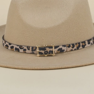 Close-up of leopard print belt buckle and golden metal pin on khaki wool felt fedora hat