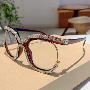 Macro detail of oversized cat-eye glasses with sparkling rhinestones on red frame